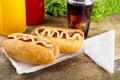 Hotdogs in the tray with ketchup with cola,lettuce on the wooden