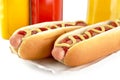 Hotdogs on tray with mustard bottles on white