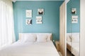 Hotel bedroom with blue walls, white curtains, pillowcases and sheets