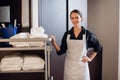 A hotel crew member in a uniform, carrying clean towels