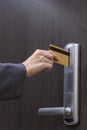 Hotel door - woman& x27;s hand inserting a magnetic stripe hotel key