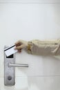 Hotel door - woman& x27;s hand inserting a magnetic stripe hotel key card in front of the electronic card key door lock