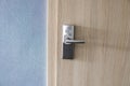 Hotel electronic lock on wooden door and with a blue wall. Royalty Free Stock Photo