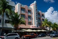 A hotel with a fleet of parked cars standing in front, illustrating a bustling scene, An Art Deco hotel in Miami, AI Generated