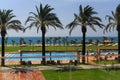 hotel grounds with swimming pool, clear blue sea and trees, summer Sunny day palm trees Royalty Free Stock Photo