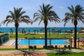 Hotel grounds with swimming pool, clear blue sea and trees, summer Sunny day palm trees Royalty Free Stock Photo