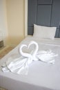 Hotel housekeeper fold white towel as two swans or heart