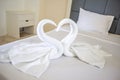 Hotel housekeeper fold white towel as two swans or heart