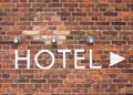 Hotel letters on a brick wall with arrow