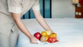 Hotel maid hand holding fruits tary  in to the luxury hotel bed room ready for tourist travel Royalty Free Stock Photo