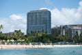 Hotel oceanfront on a sunny white sand beach on Waikiki Honolulu in Hawaii with tourist and beach goer enjoying water outdoor acti