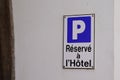 Hotel parking sign with french text means parked car is reserved hostel on wall city building facade Royalty Free Stock Photo