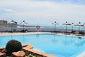 Hotel pool with parasols. Sea and blue sky background Royalty Free Stock Photo