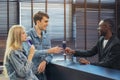 At the hotel reception, an employee serves water. Checking into the hotel as a couple