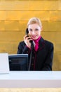 Hotel receptionist with phone on front desk Royalty Free Stock Photo