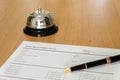 Hotel reservation form and luxury pen at reception concierge desk. With a bell ring for guest to call for a service, attention. Royalty Free Stock Photo