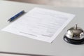 Hotel reservation form and silver vintage bell on reception desk with copy space. Hotel service, registration. Selective focus. Royalty Free Stock Photo