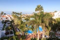 Hotel resort panorama with swimming pool, palm trees and view of the Atlantic Ocean in Playa de las Americas, Tenerife