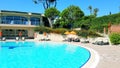 Hotel resort scene with pool, lounge chairs and pine trees Royalty Free Stock Photo