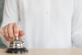 Hotel restaurant bell service on concierge customer reception counter with business person ringing pressing bell button calling Royalty Free Stock Photo