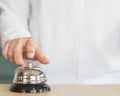 Hotel restaurant bell service on concierge customer reception counter with business person ringing pressing bell button calling Royalty Free Stock Photo