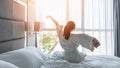 Hotel room comfort with good sleep easy relaxation lifestyle of Asian girl on bed have a nice day morning waking up Royalty Free Stock Photo
