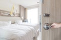 Hotel room door opened unlock to guest bedroom interior view with blur background of modern comfort bed luxury high quality living