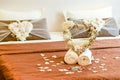 hotel room, Honeymoon, Wedding and love concept - two towels with heart on the Wedding bed topped with rose petals Royalty Free Stock Photo