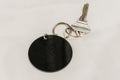 Hotel room key with round black blank pendant white background Royalty Free Stock Photo