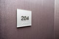 Hotel room number on textured wall Royalty Free Stock Photo