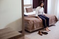 Sad tired man sitting on the bed in the hotel Royalty Free Stock Photo