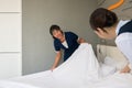 Hotel room service. Young two Asian woman maid in uniform making bed in guest room Royalty Free Stock Photo