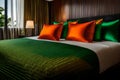 Hotel room setting with king sized bed, Thai silk orange and green pillows close up view Royalty Free Stock Photo