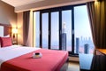 Hotel room in a skyscraper with large glass windows overlooking the city center. A romantic place full of love. Generative