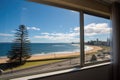 hotel room window displaying a seaside panorama