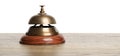 Hotel service bell on wooden table against background Royalty Free Stock Photo