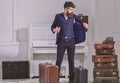 Hotel service concept. Man, traveller with beard and mustache with luggage, luxury white interior background. Macho