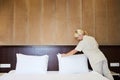 Hotel service. Made making bed in room. Royalty Free Stock Photo