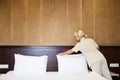 Hotel service. Made making bed in room. Royalty Free Stock Photo