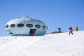 Hotel in the shape of an alien flying saucer standing high in the mountains among the snow capped mountain peaks. Dombay, Russia