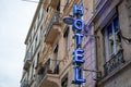 Hotel sign blue neon text in wall building facade in tourist city Royalty Free Stock Photo