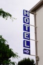 Hotel sign text blue and arrow in wall building facade in french tourist city