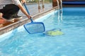 Automatic pool cleaners. Hotel staff worker cleaning the pool