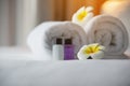 Hotel towel and shampoo and soap bath bottle set on white bed with plumeria flower decorated Royalty Free Stock Photo