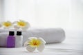Hotel towel and shampoo and soap bath bottle set on white bed with plumeria flower decorated Royalty Free Stock Photo