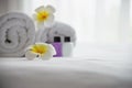 Hotel towel and shampoo and soap bath bottle set on white bed with plumeria flower decorated Royalty Free Stock Photo