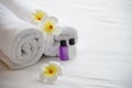 Hotel towel and shampoo and soap bath bottle set on white bed with plumeria flower decorated Royalty Free Stock Photo