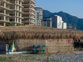 Hotel under construction on the beach. Black Sea coast. Construction industry. Building frame. Thatched roof restaurant. Vacation Royalty Free Stock Photo