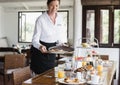 Hotel waitress serving food on the table Royalty Free Stock Photo