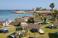 Hotels beach with turquoise water of Mediterranean sea with boat and trees Royalty Free Stock Photo